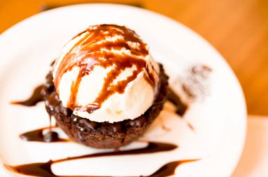 Bir brownie çikolata sos plaka ile üstüne lezzetli dondurma closeup