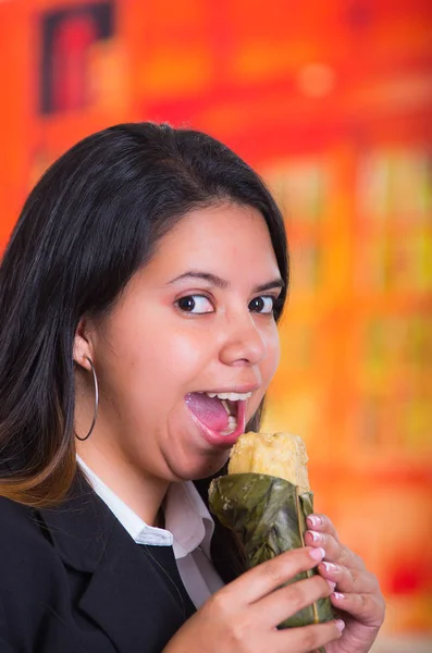 Prachtige vrouw, eten van een quimbolito, de traditionele Andes voedsel concept — Stockfoto