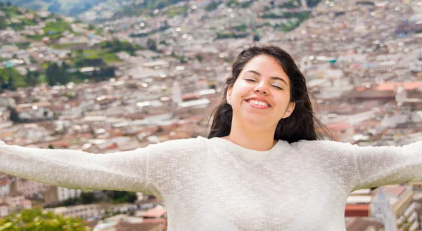Ελευθερία Λατινική κορίτσι λαμβάνει τις ακτίνες του ήλιου πάνω από το πρόσωπό ενώ ευτυχώς χαμογέλασε όταν μια αποικιακή πόλη βρίσκεται πίσω της — Φωτογραφία Αρχείου