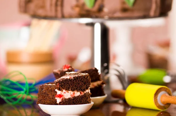 Deliziosi pezzi di torta al cioccolato con ripieno di crema seduti su piccoli piatti, concetto di pasticceria — Foto Stock