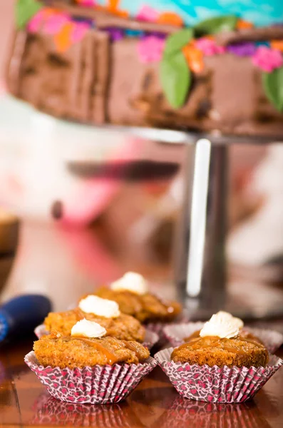 Deliziosi muffin color marrone con salsa caramello e crema di condimento, torta colorata sullo sfondo, concetto di pasticceria — Foto Stock