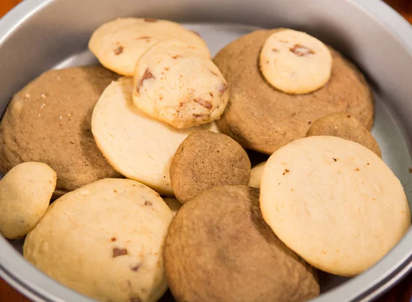 Urval av olika storlek brun färgad cookies, liggande i en skål som sett ovanifrån, konditorivaror koncept — Stockfoto