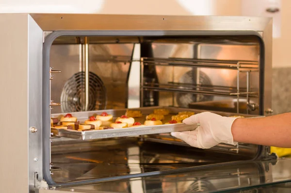 Deliziosi biscotti in un vassoio inserito all'interno di un moderno e utile forno commerciale per il pane — Foto Stock