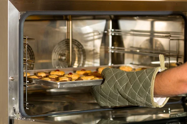 Deliziosi biscotti in un vassoio inserito all'interno di un moderno e utile forno commerciale per il pane — Foto Stock