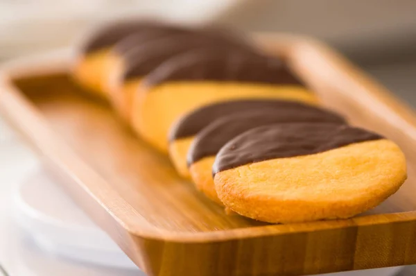 Closeup of a delicious fresh vanilla cookie with chocolate on wooden desk — Stock Photo, Image