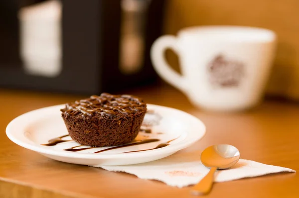 Délicieux gâteau au chocolat dans une assiette sur table rustique en bois avec une cuillère sur une serviette — Photo