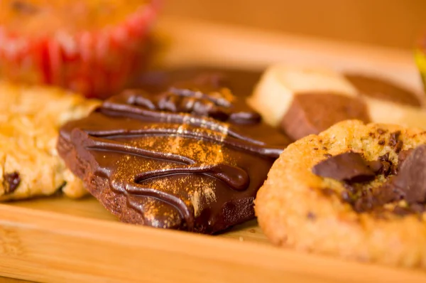 Biscotti alla vaniglia appena sfornati e gocce di cioccolato su vassoio di legno — Foto Stock