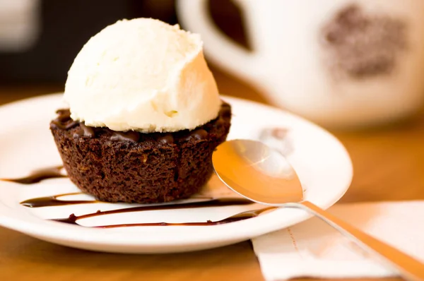 Крупным планом вкусного мороженого поверх брауни с шоколадным соусом в тарелке — стоковое фото