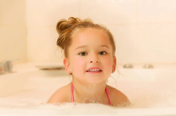 Beetje mooi meisje spelen met water en schuim in Bad — Stockfoto