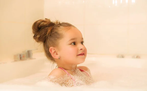 Little beautiful girl playing with water and foam in bath — Stock Photo, Image