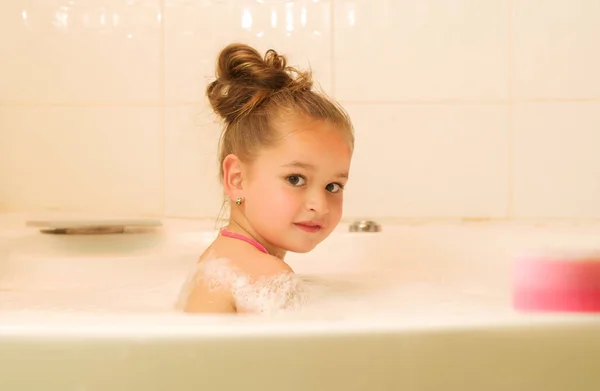 Little beautiful girl playing with water and foam in bath — Stock Photo, Image