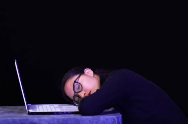 Koyu arka plan üzerinde onun gözlük onu laptop üzerinde güzel kız uyuya kalmışım