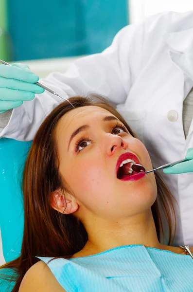 Hermosa paciente que recibe tratamiento dental en el consultorio de dentistas. Mujer visitando a su dentista —  Fotos de Stock