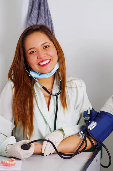 Bella donna medico prende una pressione dei pazienti in studio dentistico — Foto Stock