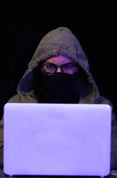 Portret van hacker met laptop op donkere achtergrond — Stockfoto