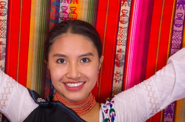 Close-up van een mooie Spaanse model dragen van de Andes traditionele kleding glimlachend en poseren voor de camera, kleurrijke stoffen achtergrond — Stockfoto