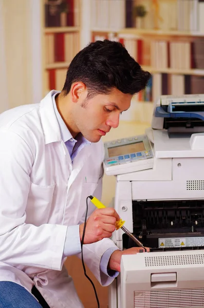 Knappe man tot vaststelling van een fotokopieerapparaat tijdens het onderhoud met behulp van een schroevendraaier — Stockfoto