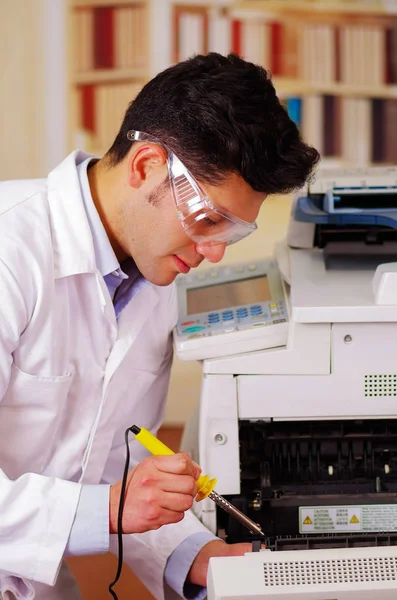 Hansdome mann fixiert während der Wartung einen Kopierer mit einem Schraubenzieher mit Arbeitsbrille — Stockfoto