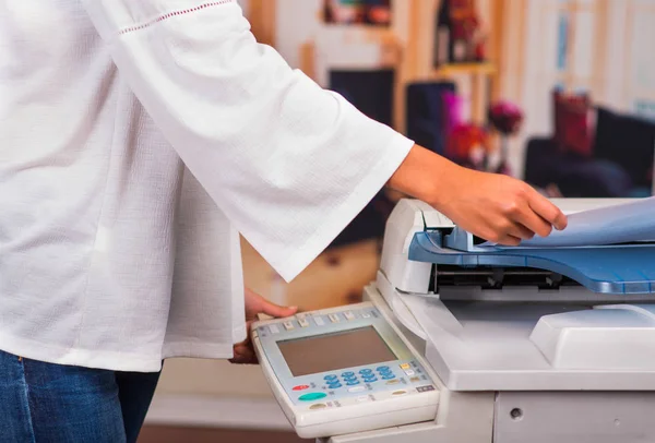 Jonge zakenvrouw met kopieermachine op kantoor — Stockfoto