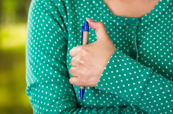 Primo piano di una mano femminile che tiene una penna. concetto di giocherellone — Foto Stock