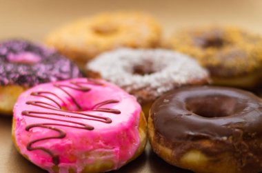 Bir yumuşak kahverengi arka planda sırlı farklı bir lezzetli çeşitli donuts yakın çekim