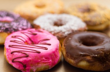 Bir yumuşak kahverengi arka planda sırlı farklı bir lezzetli çeşitli donuts yakın çekim
