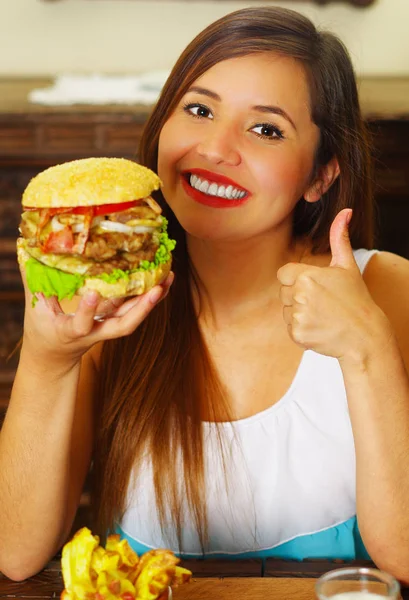 Wanita cantik di kafe menyetujui hamburger lezat dengan jempol ke atas — Stok Foto