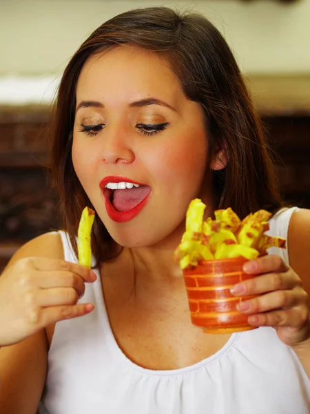 Close up of a beauty woman in a restaurant eating a delicious french fries — Stock Photo, Image