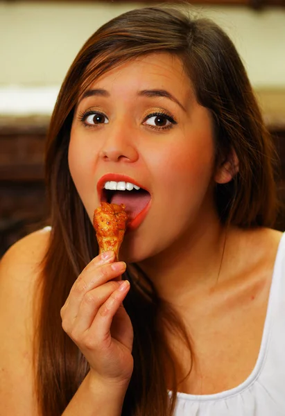 Close up van een schoonheid vrouw in een restaurant eten een heerlijke kippenvleugeltjes — Stockfoto
