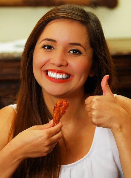 Primo piano di una donna di bellezza nel ristorante che approva un delizioso ali chiken con un pollice in su — Foto Stock