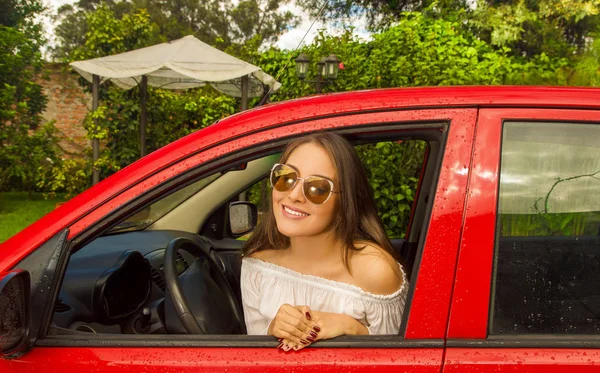 Bela sexy jovem mulher no vermelho carro vestindo um sol óculos e posando para câmara — Fotografia de Stock