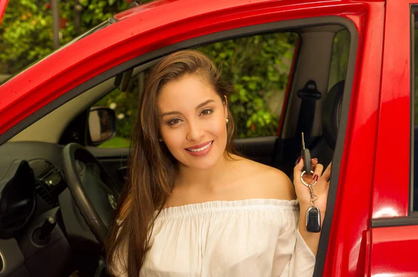 Belle jeune femme sexy en voiture rouge tenant les clés et souriant — Photo