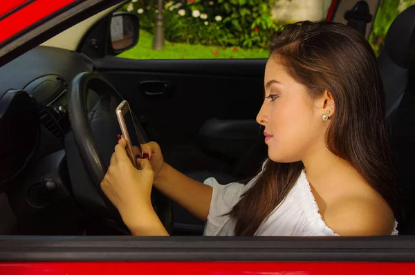 Close up of a beautiful sexy young woman in red car texting from her cellphone — Stock Photo, Image