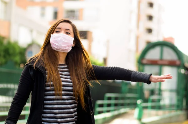 Jovem com máscara protetora na rua da cidade com poluição do ar, pedindo um táxi, fundo da cidade — Fotografia de Stock