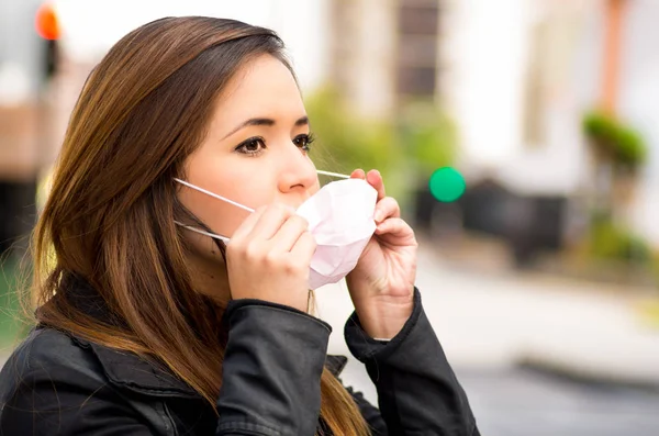 Zblízka mladé ženy nosit ochrannou masku na ulici ve městě s znečištění ovzduší, město pozadí — Stock fotografie