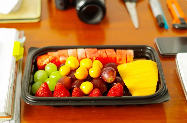 Close up van een gezond ontbijt, fruitsalade, verpakt in plastic doos op houten tafel — Stockfoto