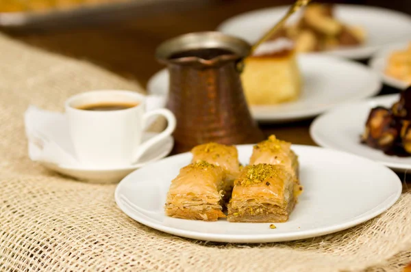 Закрыть вкусный завтрак традиционной турецкой еды баклава с фисташками и белой чашкой кофе — стоковое фото