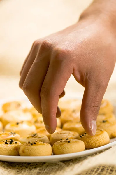 Man use his hand to take a deliciousTurkish homemade savory cookies, tuzlu kurabiye — Stock Photo, Image