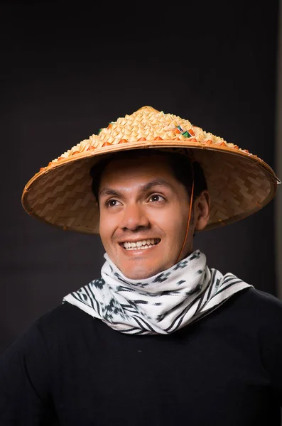 Retrato de un guapo joven empresario hispano sonriente con un sombrero cónico asiático en fondo negro —  Fotos de Stock