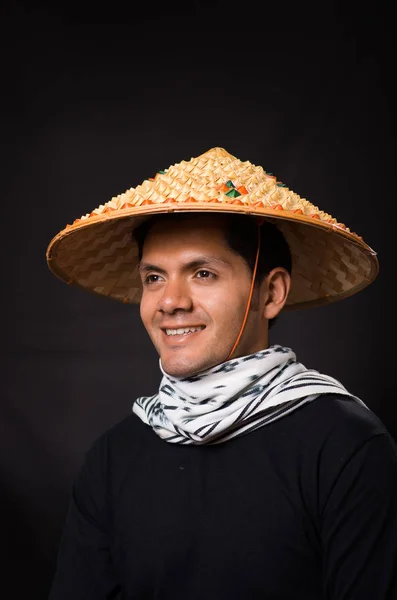 Retrato de un joven hombre de negocios hispano guapo con un sombrero cónico asiático en fondo negro —  Fotos de Stock