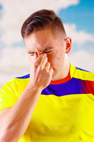 Joven ecuatoriano vistiendo camiseta oficial de fútbol maratón de pie frente a cámara, lenguaje corporal muy comprometido viendo el juego con gran entusiasmo, cielo azul y fondo de nubes —  Fotos de Stock