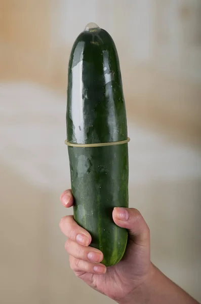 Concombre dans un préservatif masculin sur fond flou, concept de relations sexuelles protégées — Photo