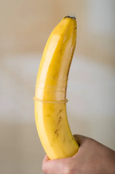 Мужской презерватив, покрывающий банан, безопасный секс, семейный план, профилактика заболеваний, передающихся половым путем — стоковое фото