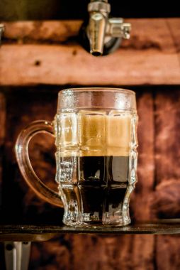 Lezzetli zanaat bira bir pint cam ahşap arka plan üzerinde