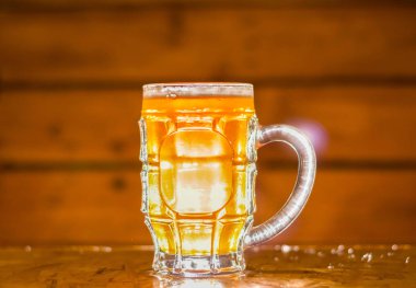 Sarışın bir zanaat bira ahşap arka plan üzerinde bir pint cam içine dolu yakın çekim