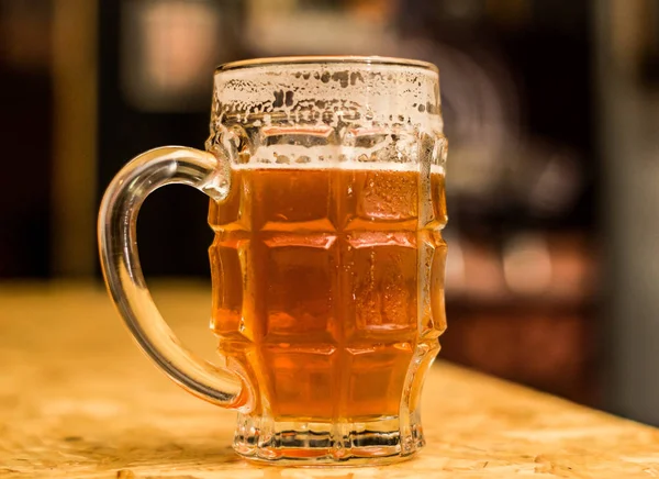 Close up de uma cerveja artesanal loira preenchida em um copo de cerveja na mesa de madeira — Fotografia de Stock