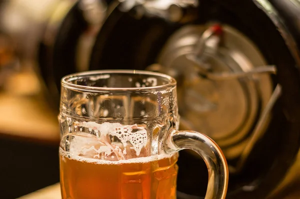 Close up de uma cerveja artesanal loira preenchida em um copo de cerveja na mesa embaçada — Fotografia de Stock