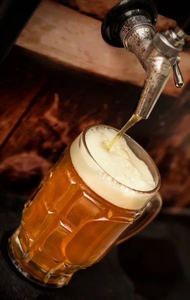Deliciosa cerveza artesanal rubia llena en un vaso de cerveza en la mesa de madera — Foto de Stock