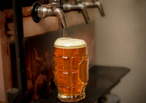 Deliciosa cerveja artesanal loira preenchida em um copo de cerveja na mesa de madeira — Fotografia de Stock