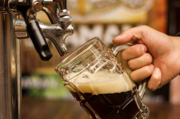 Barman zaplňují tmavé pivo řemesla pivo sklo — Stock fotografie
